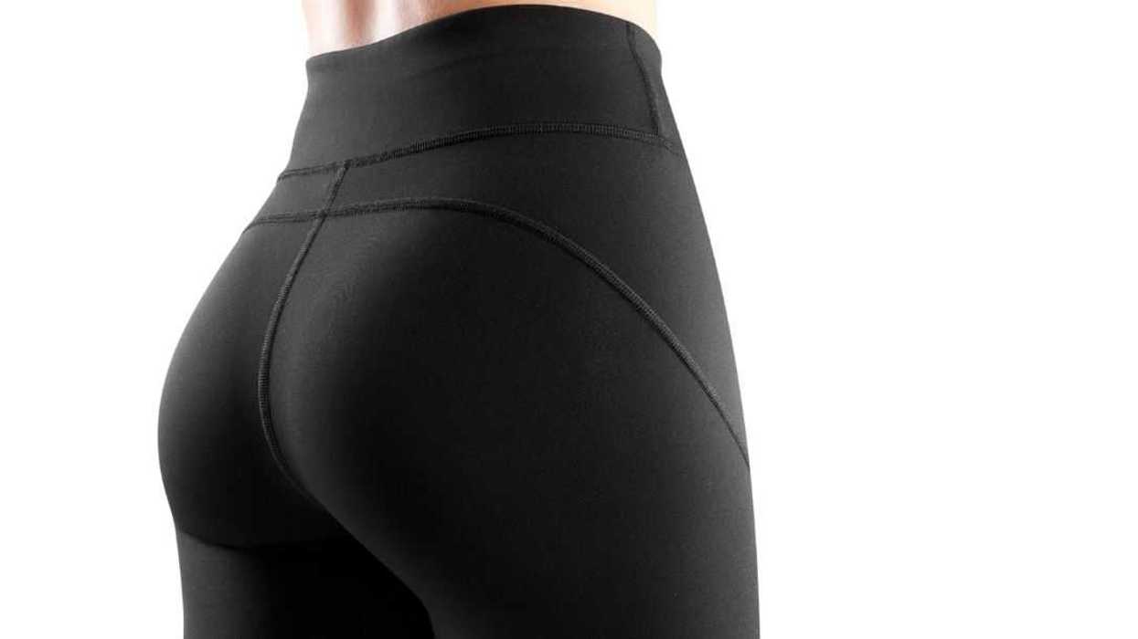 Cropped image of the back of a female model dressed in tight black leggings. Sportswear concept.