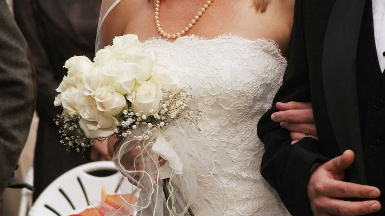 Cropped photo of a bride and groom walking down the aisle.