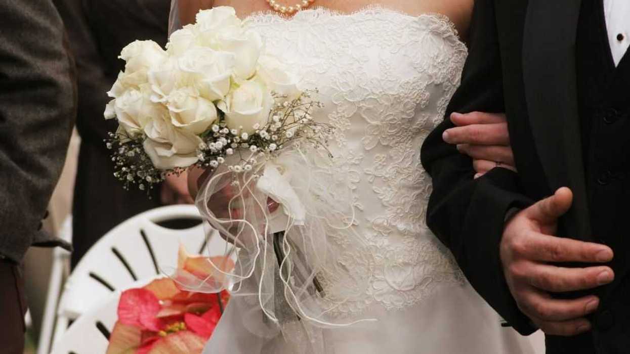 Cropped photo of a bride and groom walking down the aisle.