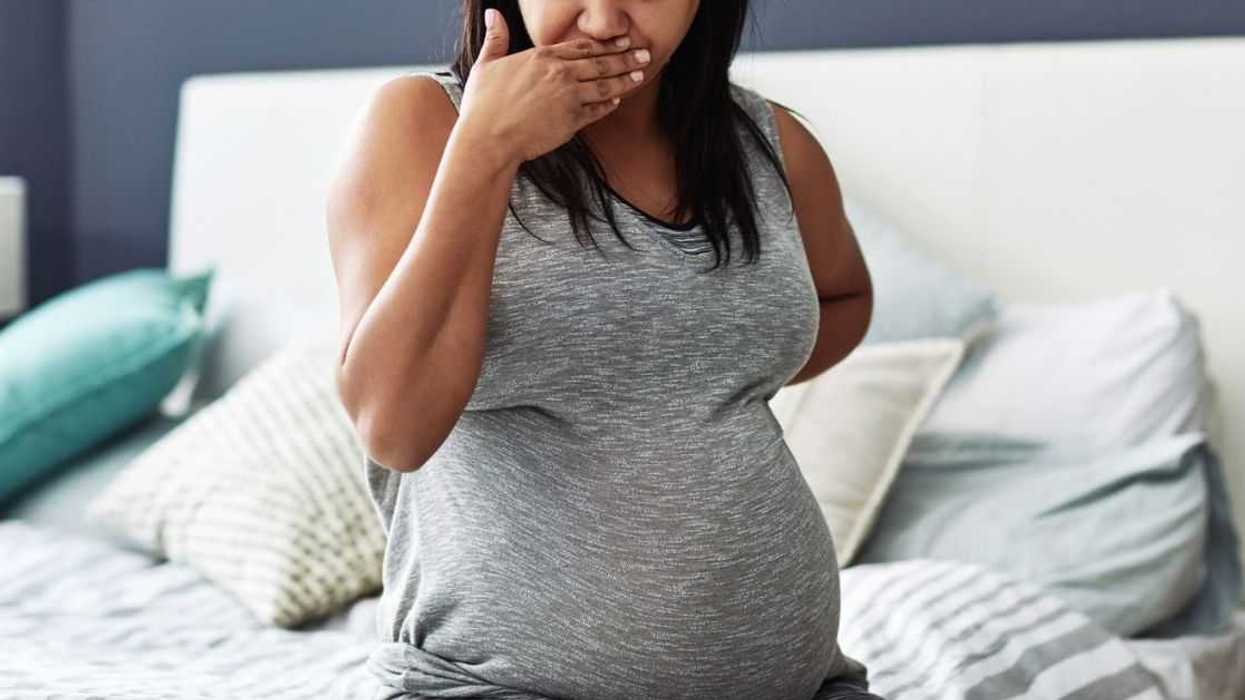 Cropped shot of a pregnant woman feeling nauseous.