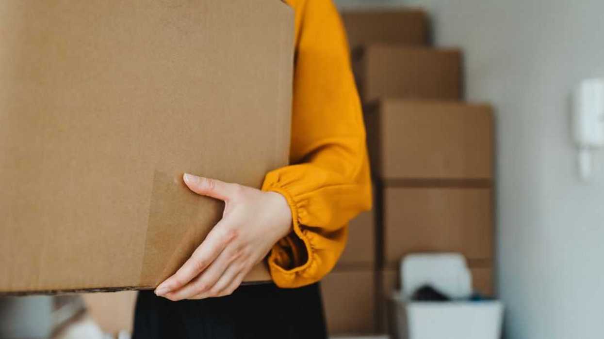 Cropped shot of a young woman moving into her new home, carrying cardboard boxes in the living room in her new apartment. Home moving and delivery services. Unpacking. New home ownership. Relocation. A new chapter in life.