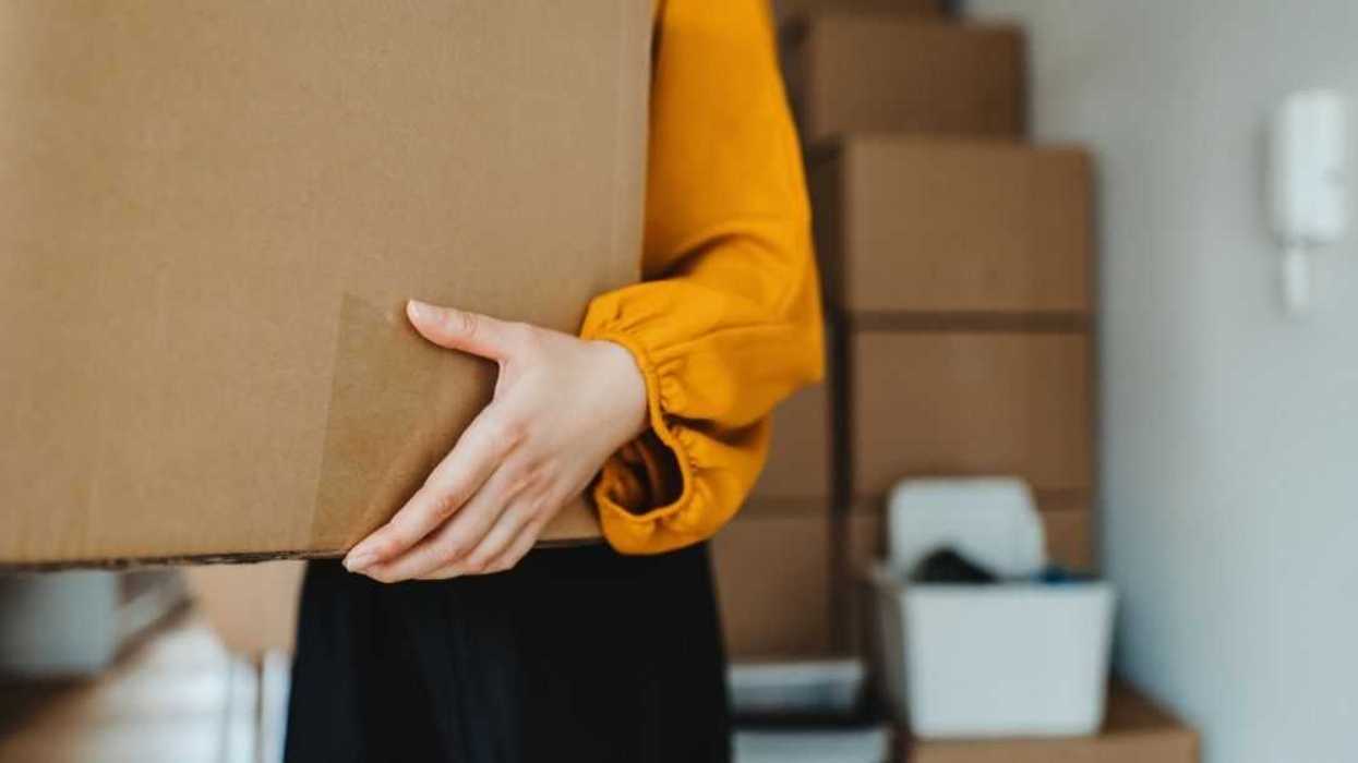 Cropped shot of a young woman moving into her new home, carrying cardboard boxes in the living room in her new apartment. Home moving and delivery services. Unpacking. New home ownership. Relocation. A new chapter in life.