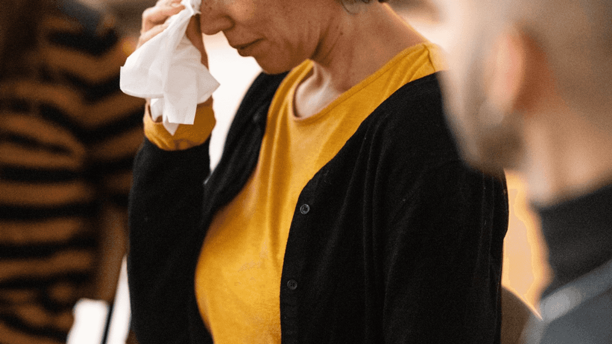 crying older woman flanked by two people