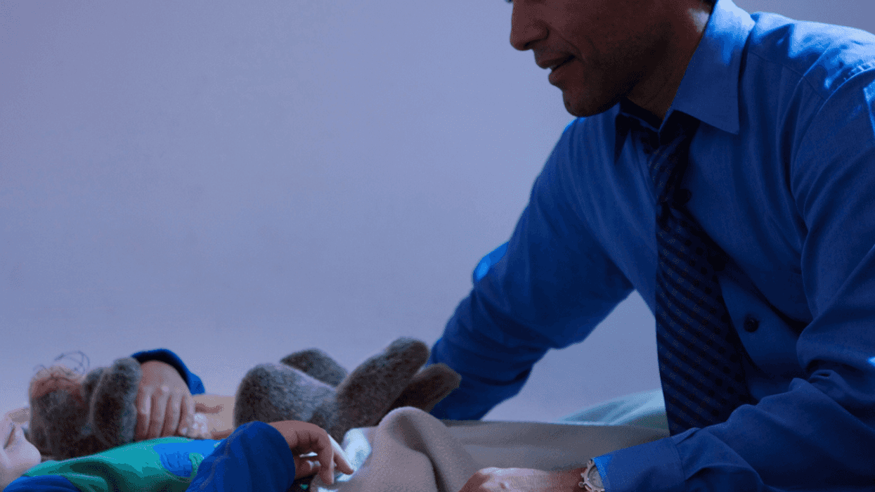 Dad tucking in son for bed