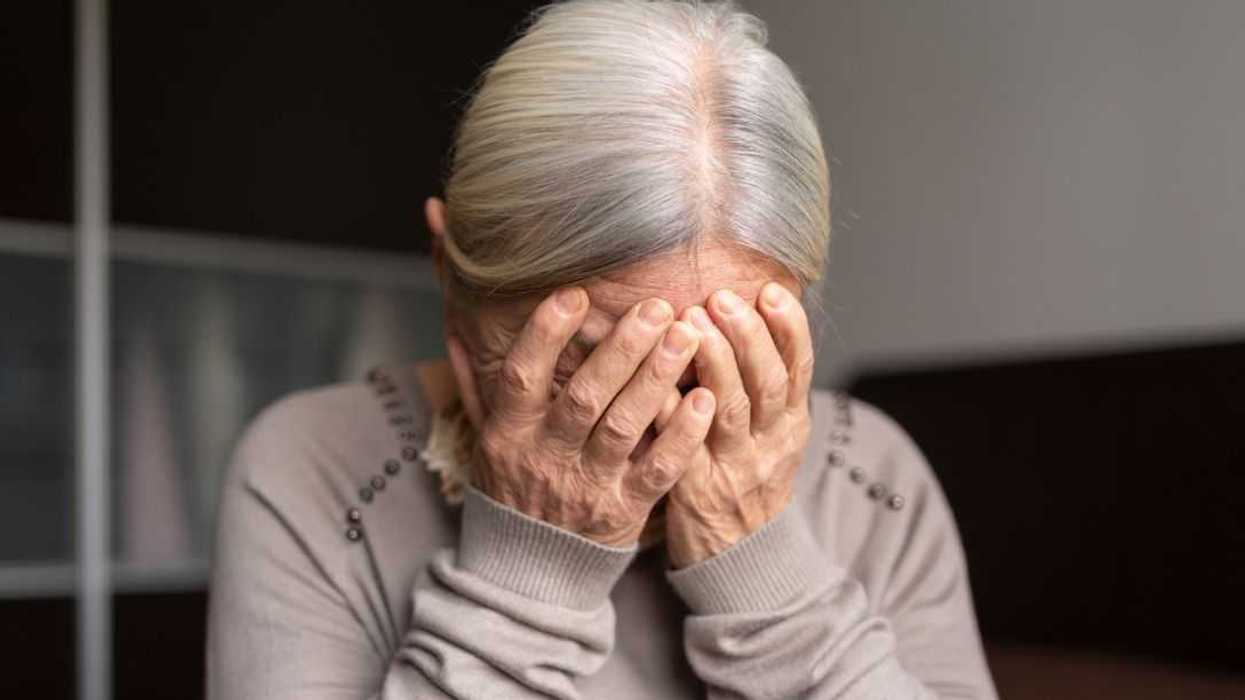 Depressed Senior Woman Covers Her Face With Both Hands.