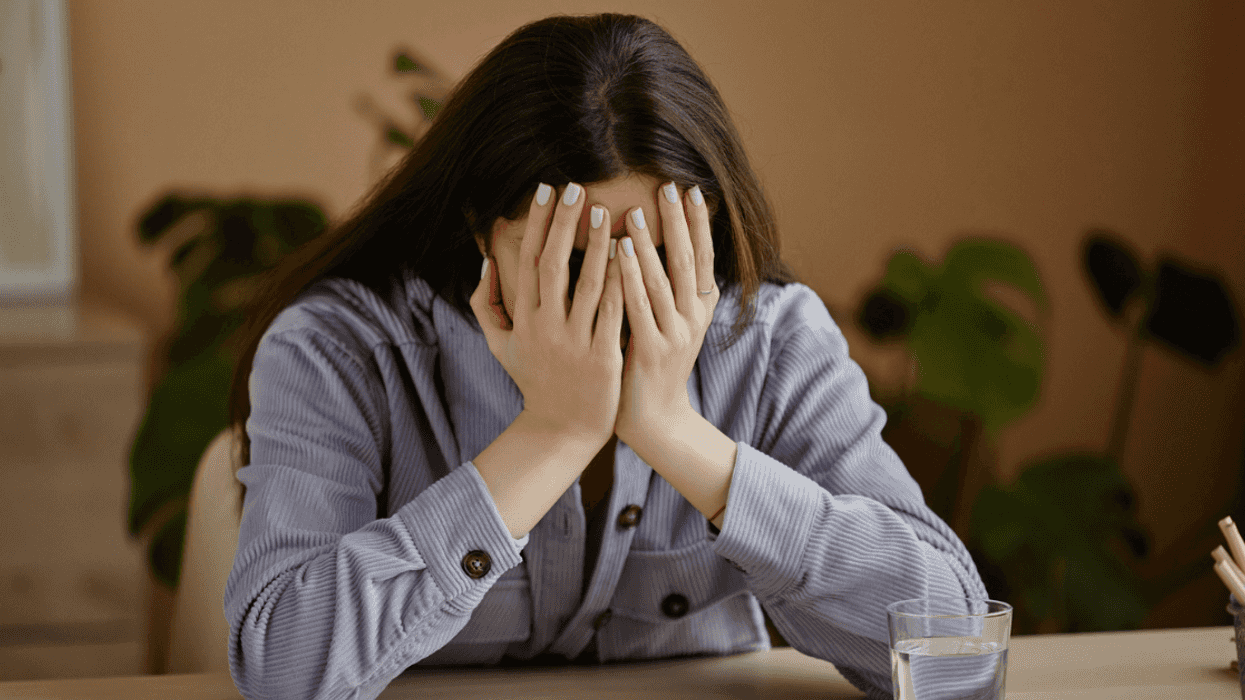depressed young woman with face in hands