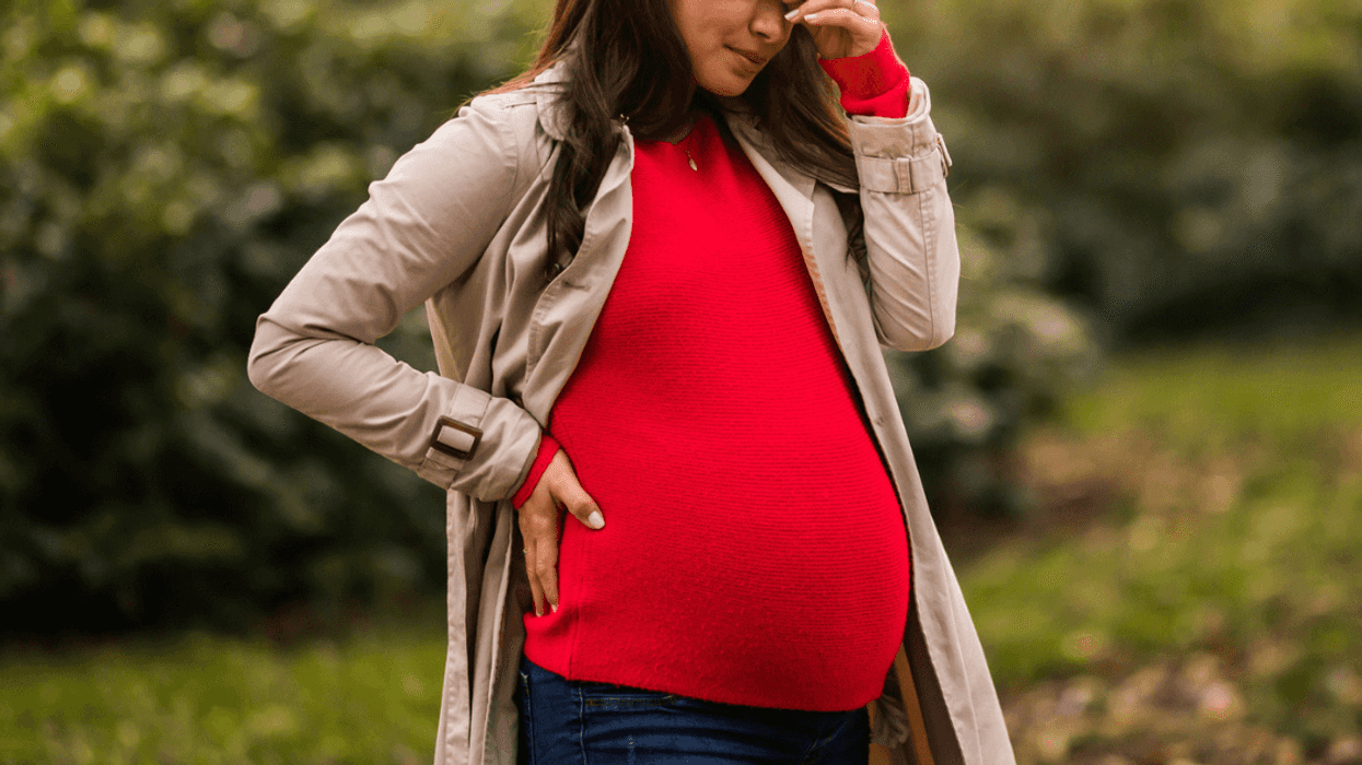Distressed pregnant woman standing outside