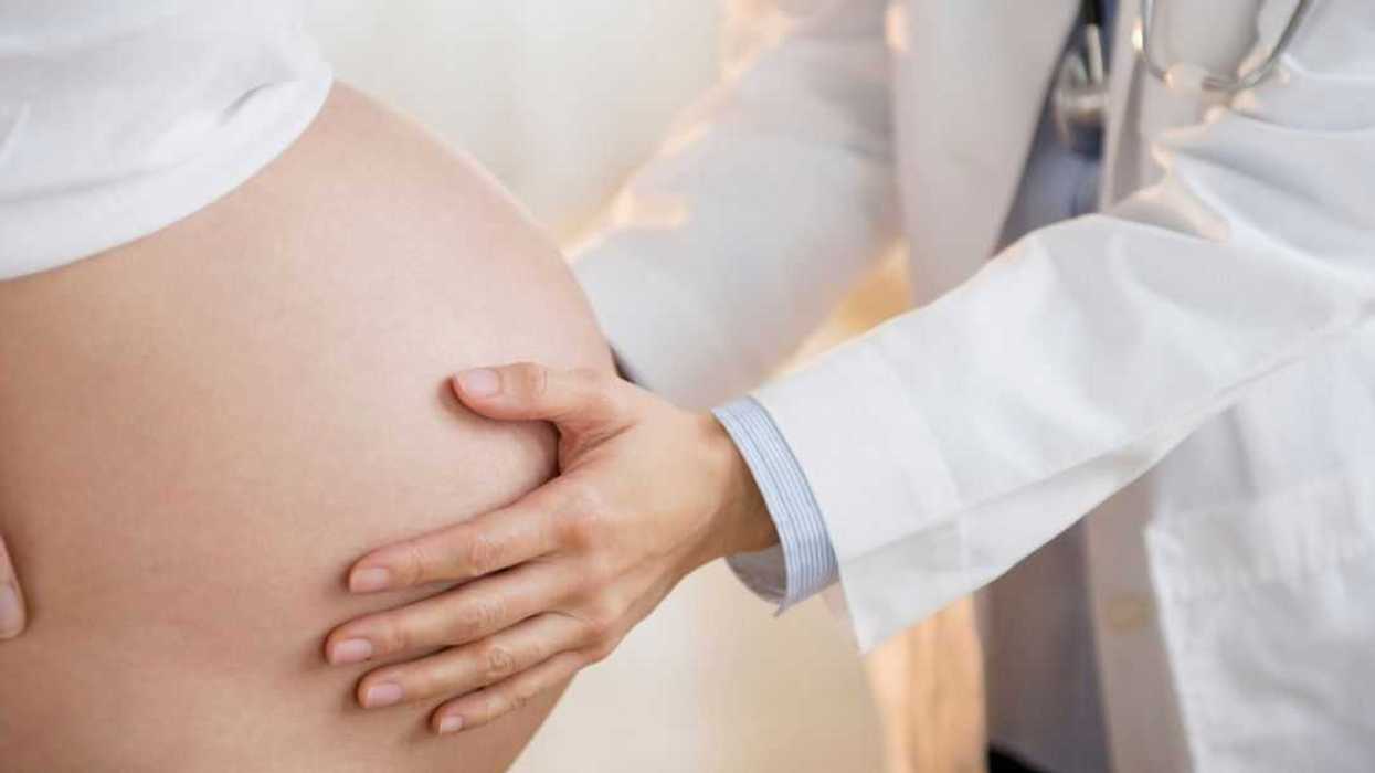 Doctor examining belly of a pregnant woman.