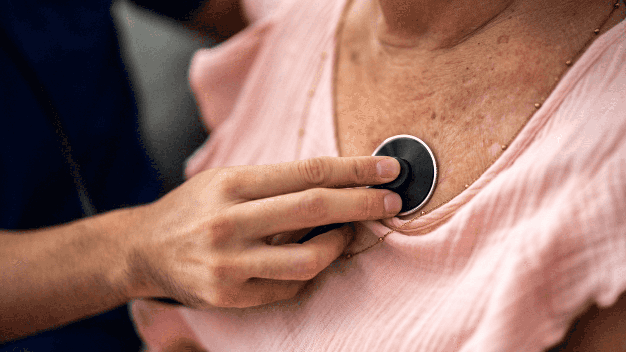 doctor listening to older woman's heart