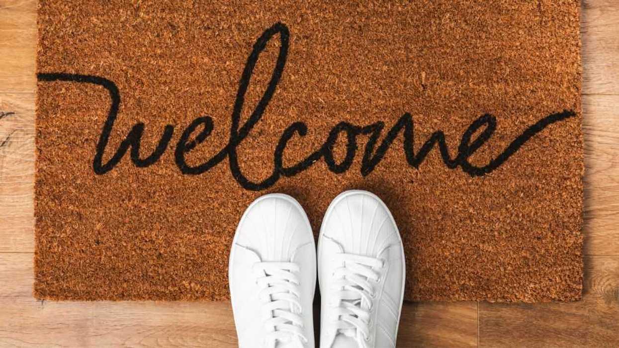 Doormat. Welcome mat on the floor background. Women's shoes on a doormat on background.