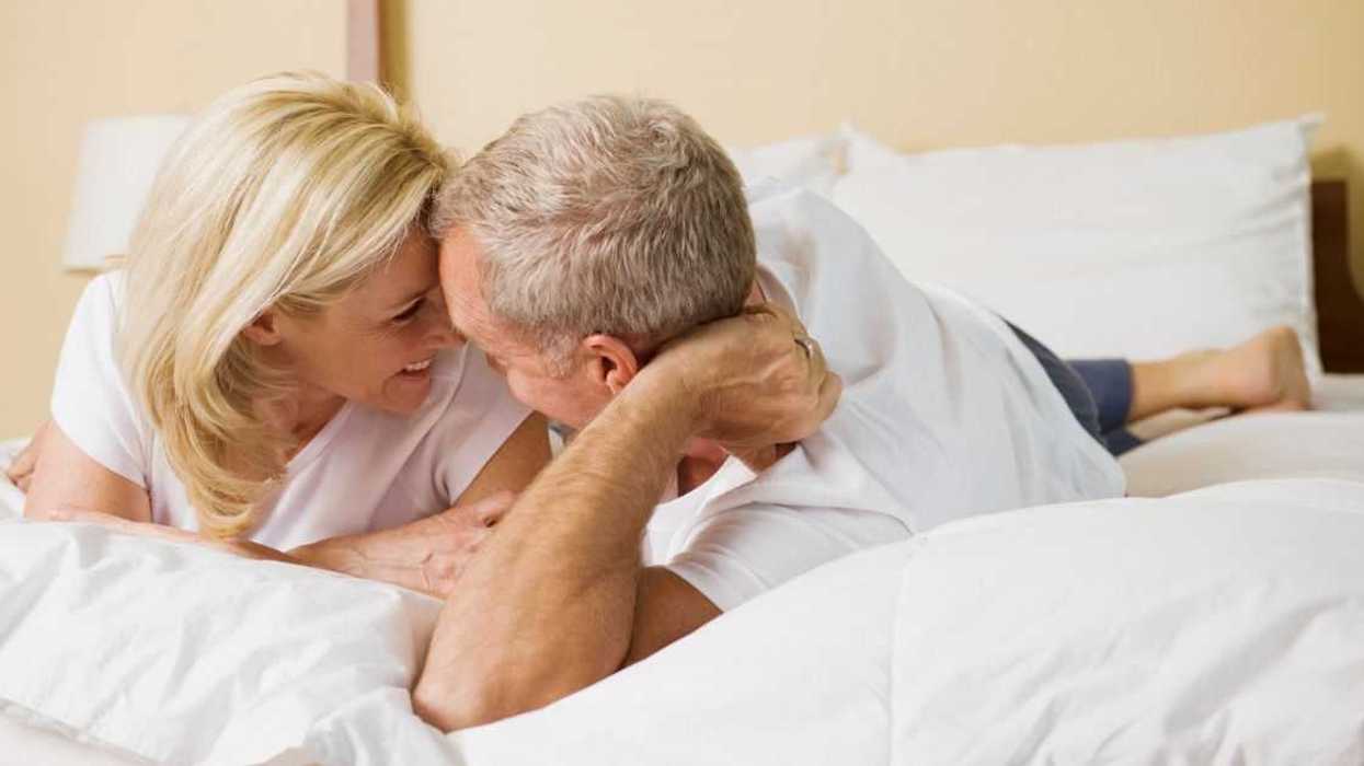 Elderly couple talking in bed