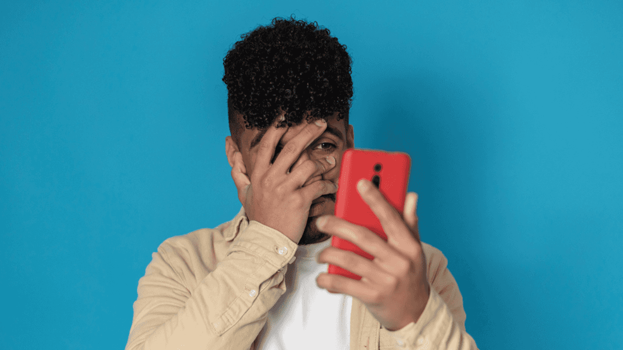 Embarrassed guy looking at phone
