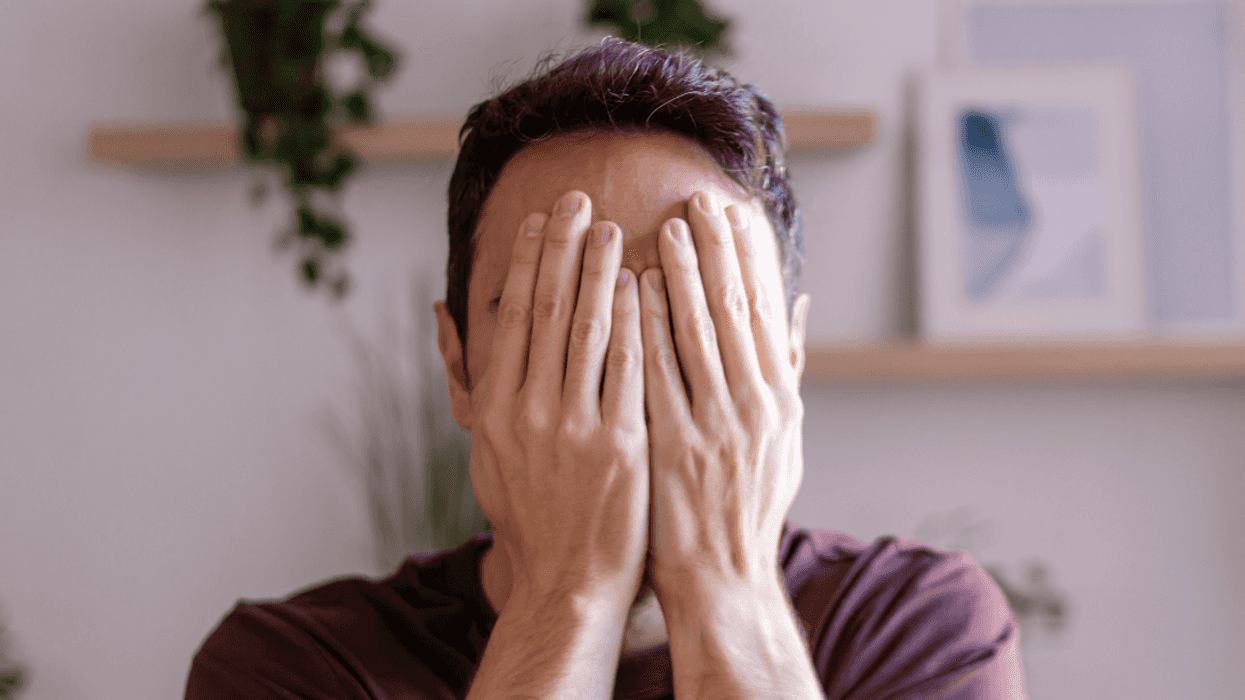 embarrassed man covering his face