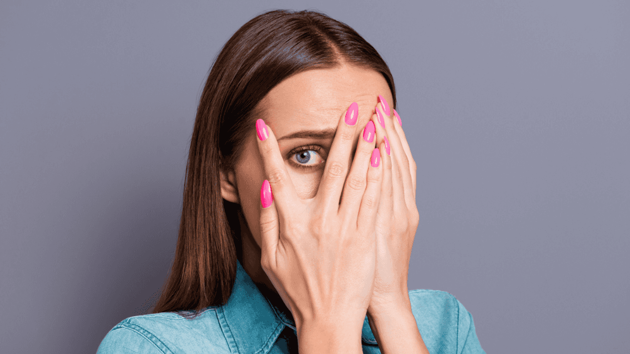 Embarrassed woman looking through her fingers