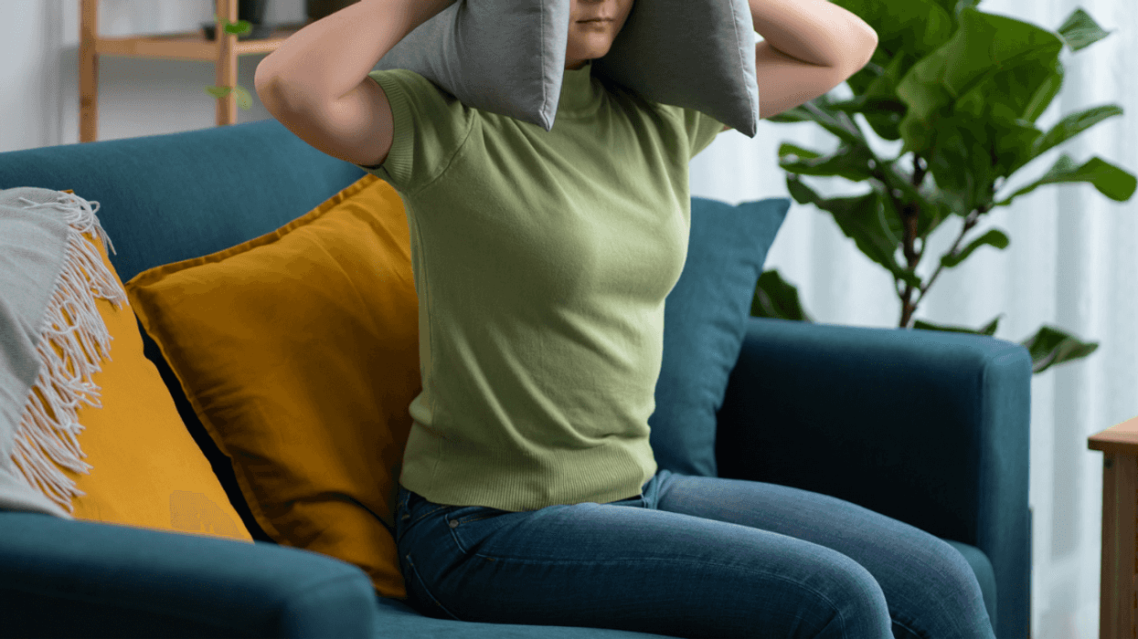 enraged woman with pillow over her head.