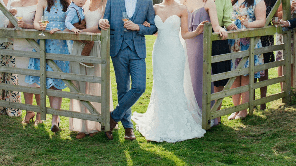 family wedding portrait by a rustic wooden fence