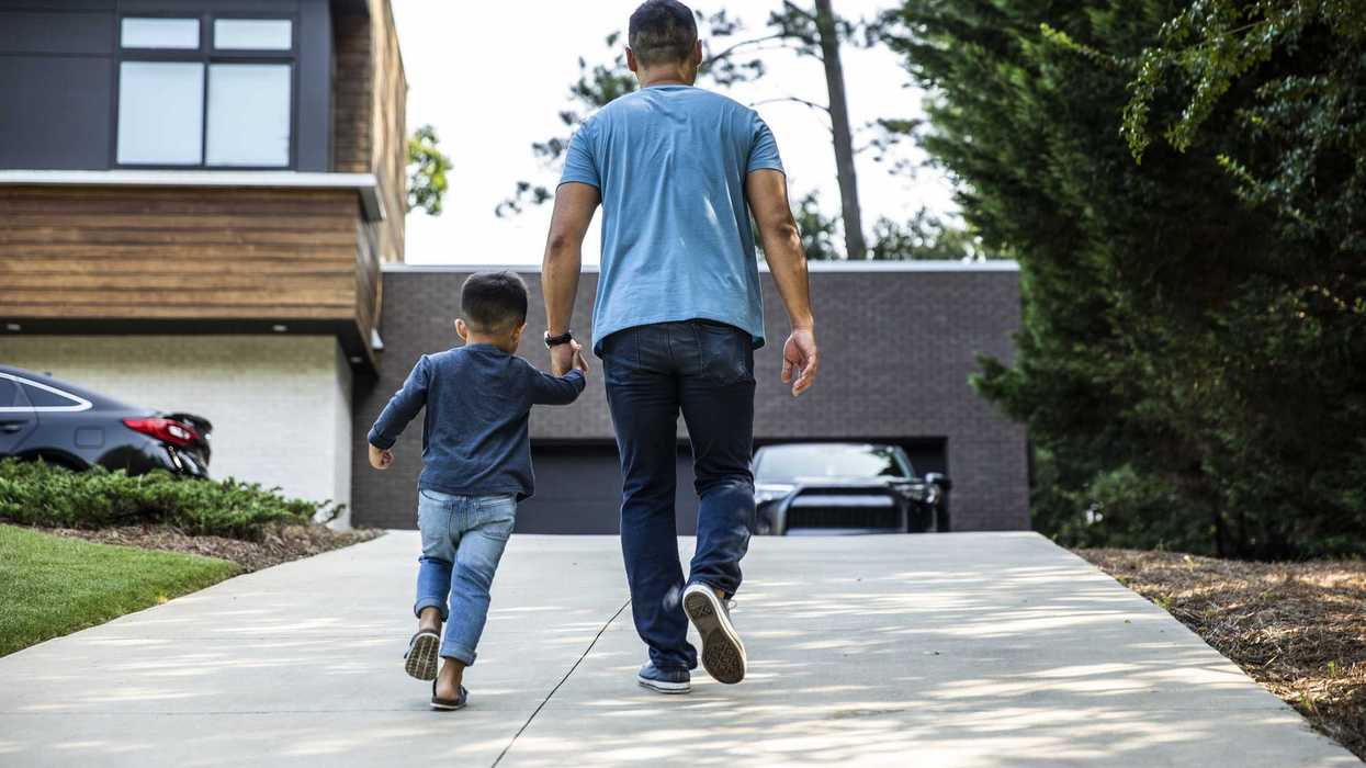 Father walking up driveway with son