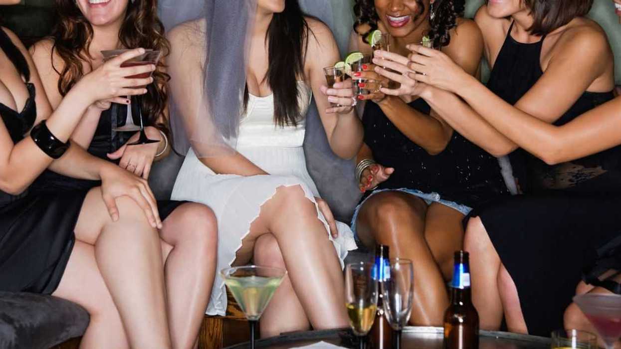 Friends drinking cocktails with bride in nightclub