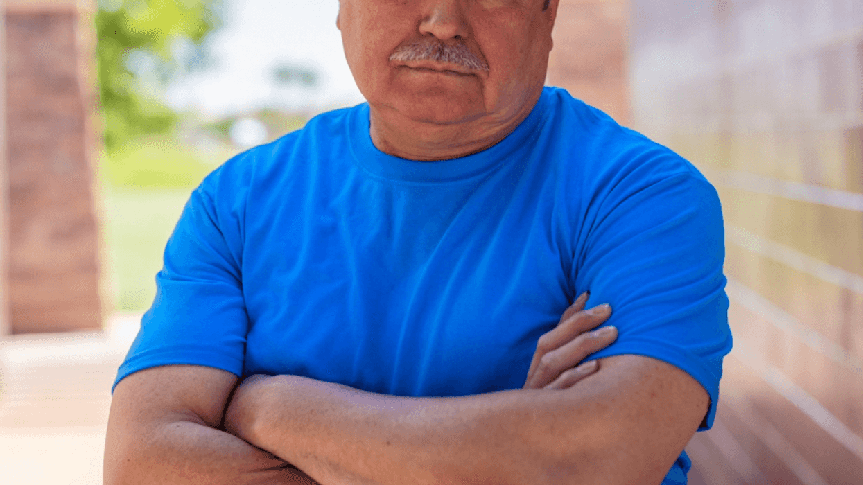 frowning older man with arms crossed