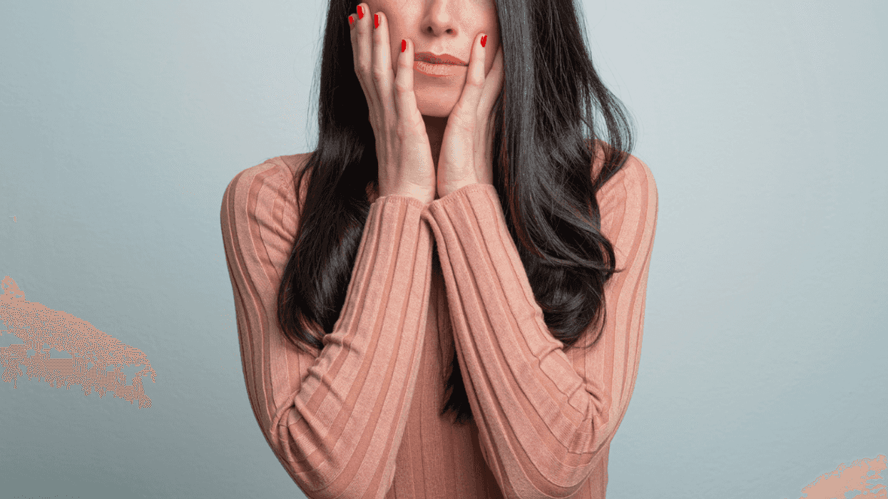 Furious woman with her hands to her face