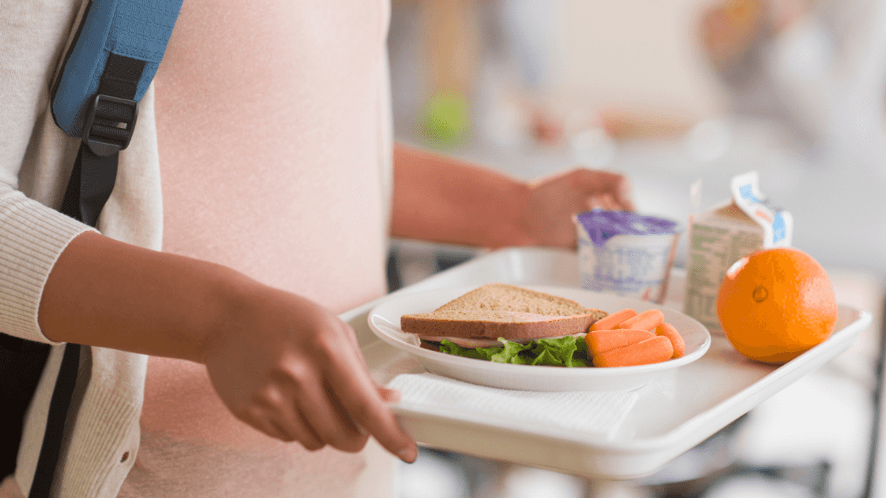 Girl holding a tray in cafeteria