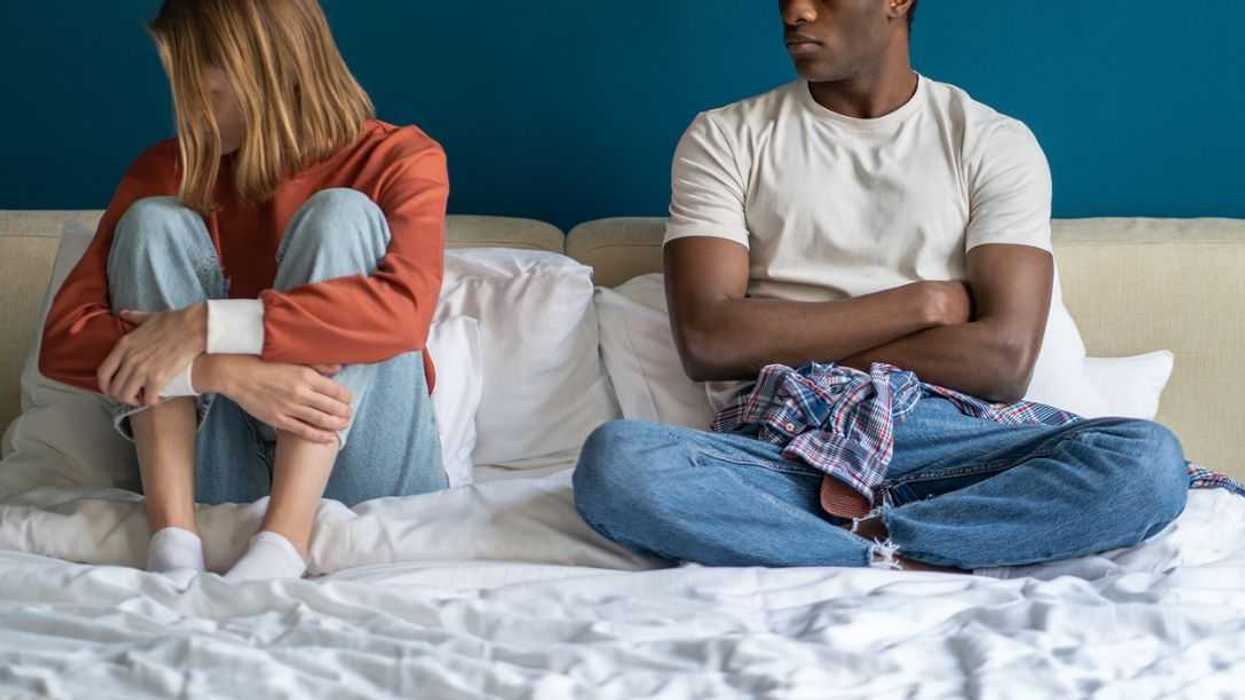 Girl ignoring guy sitting in bed at home, couple conflict quarrel in relationships.