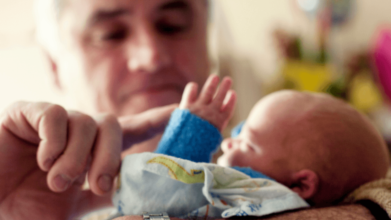 grandfather holding newborn grandchild