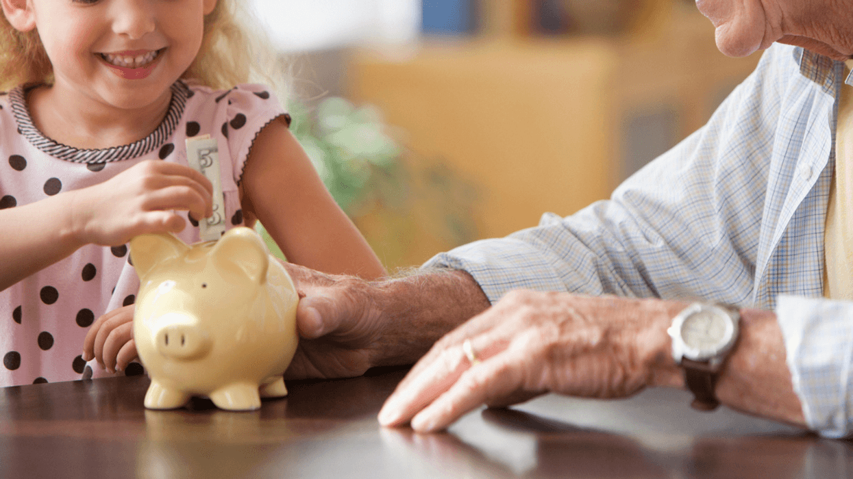 Grandparent sharing a piggy bank with grandchild