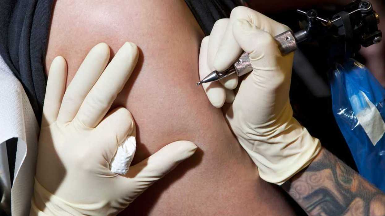 Guy getting tattoo on his arm