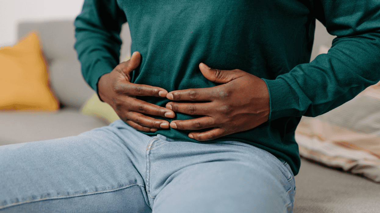 Guy holding his stomach with discomfort