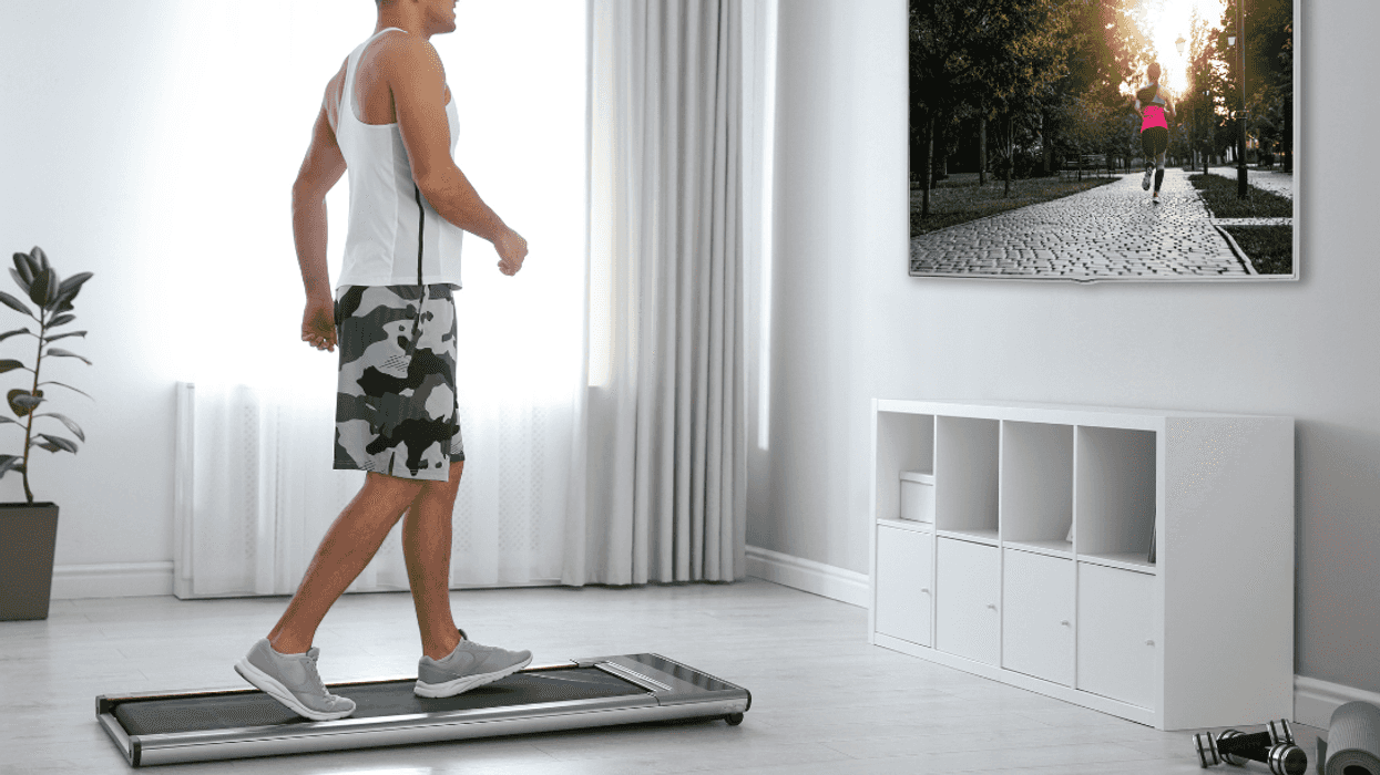 Guy in a white shirt on a walking pad in front of the television