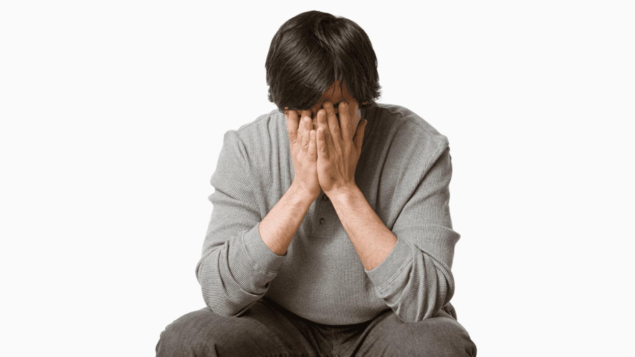 Guy with his face in his hands