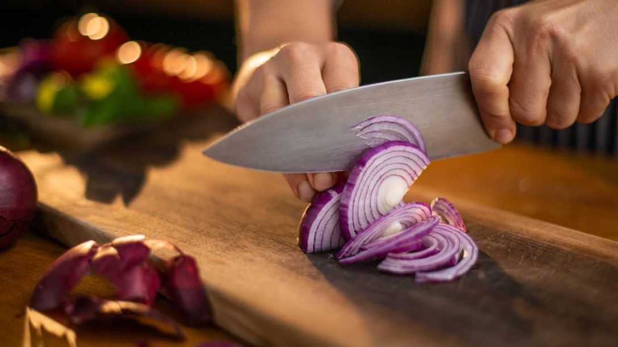 Hands cutting onions.
