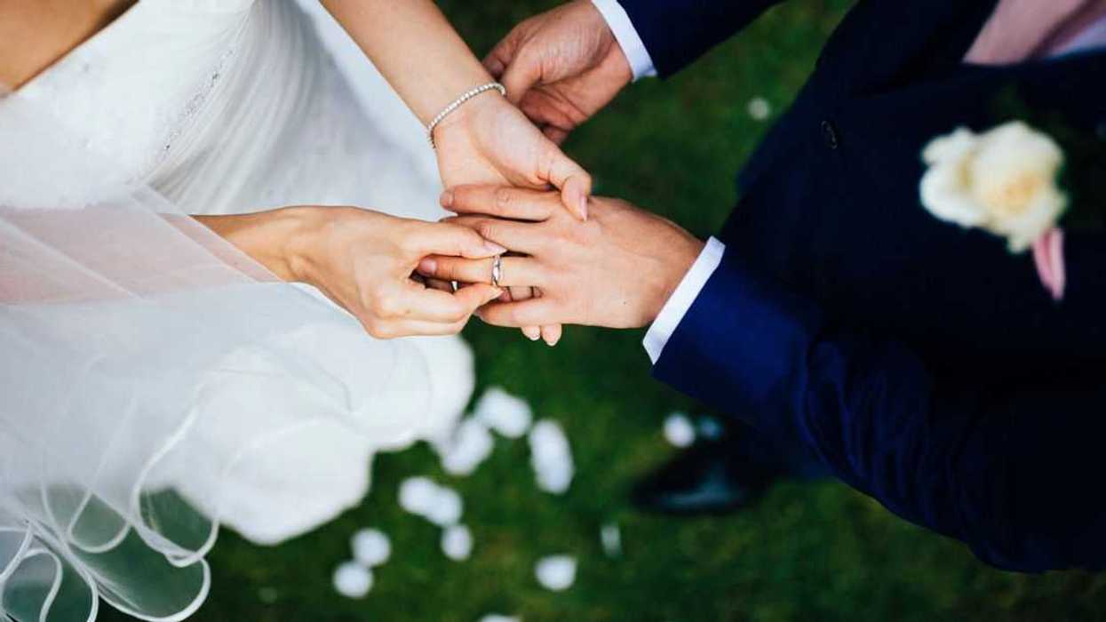 High angle view of a husband and wife exchanging vows and rings during their wedding ceremony.