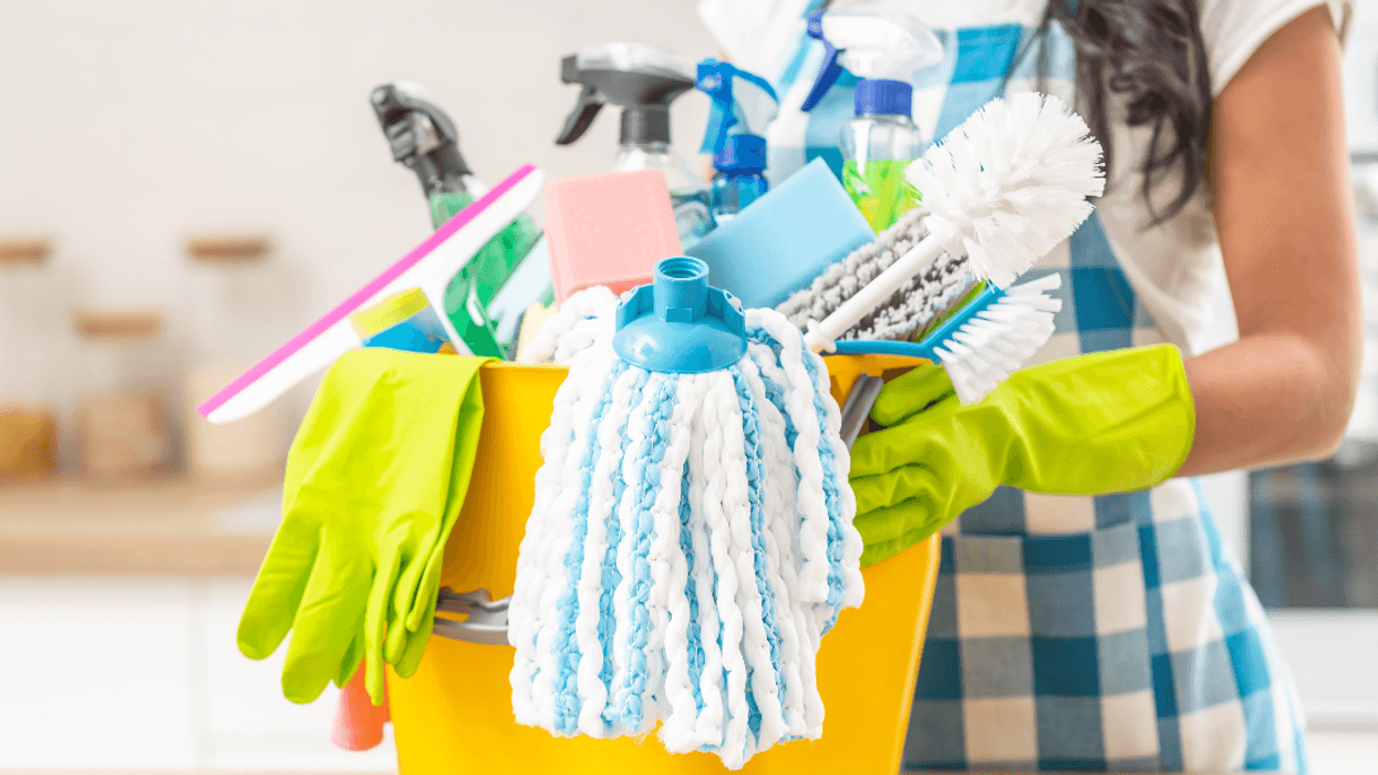 housekeeper with bucket of cleaning supplies