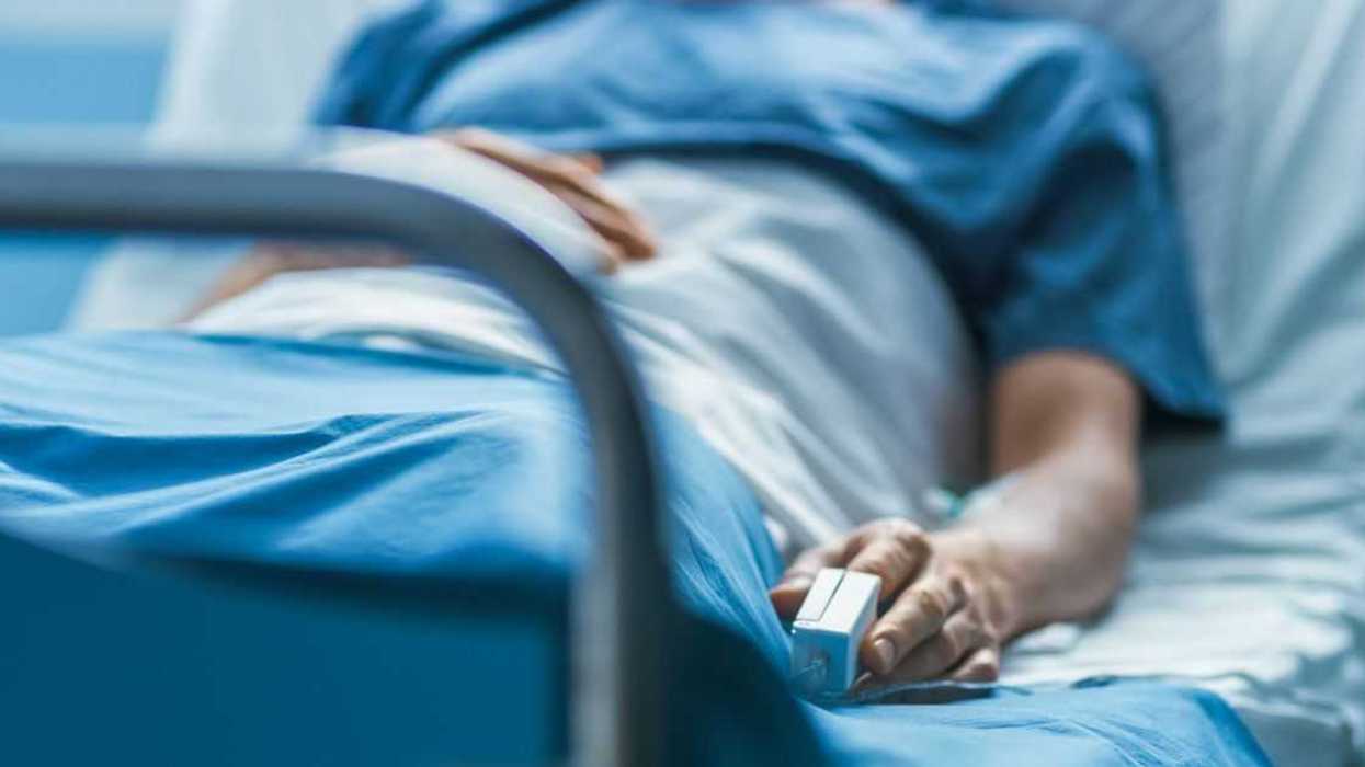 In the Hospital Sick Male Patient Sleeps on the Bed. Heart Rate Monitor Equipment is on His Finger.