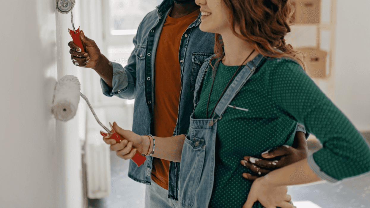 Interracial couple painting a wall