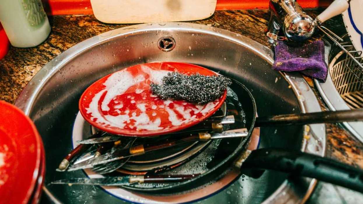 Kitchen sink full of dirty dishes.