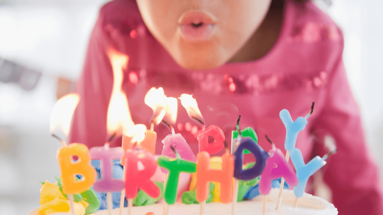 Little girl blowing out birthday candles.