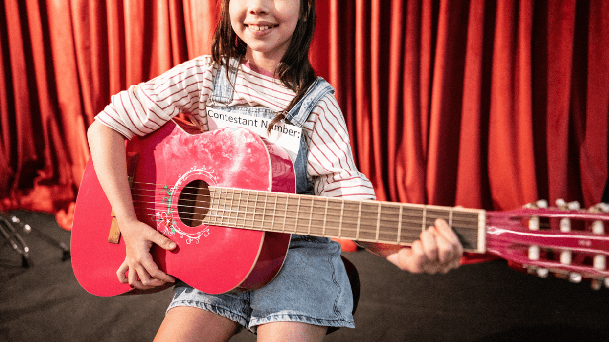 Little girl playing a guitar