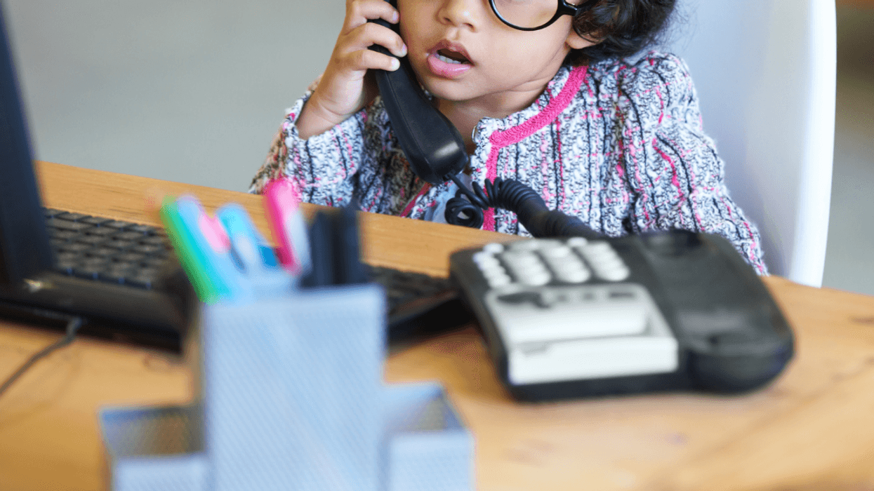 little girl seated at office desk