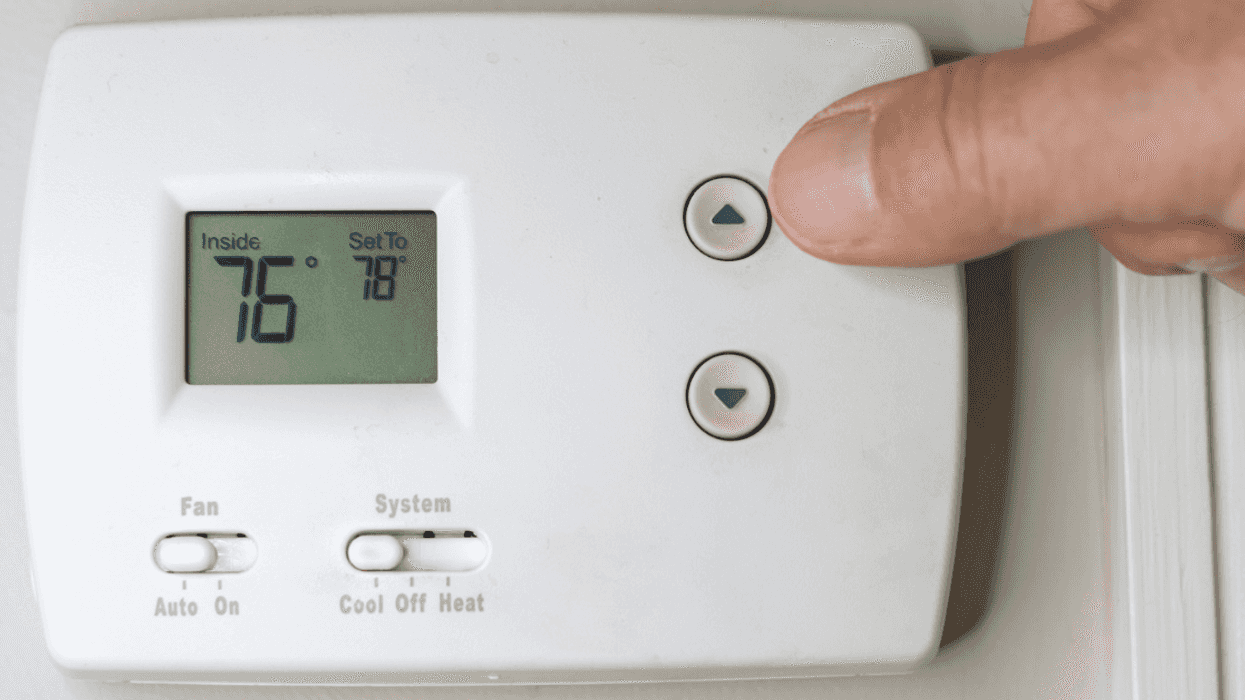 Man adjusting a thermostat