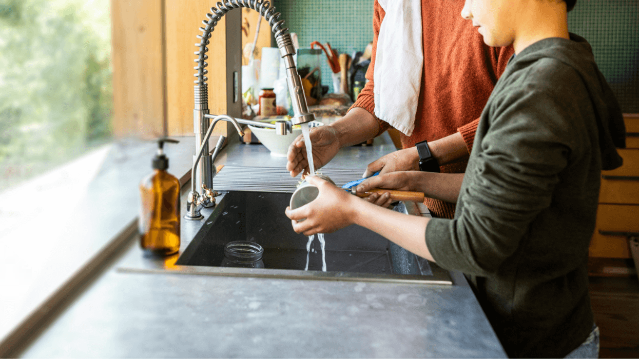 Man and child washing dishes