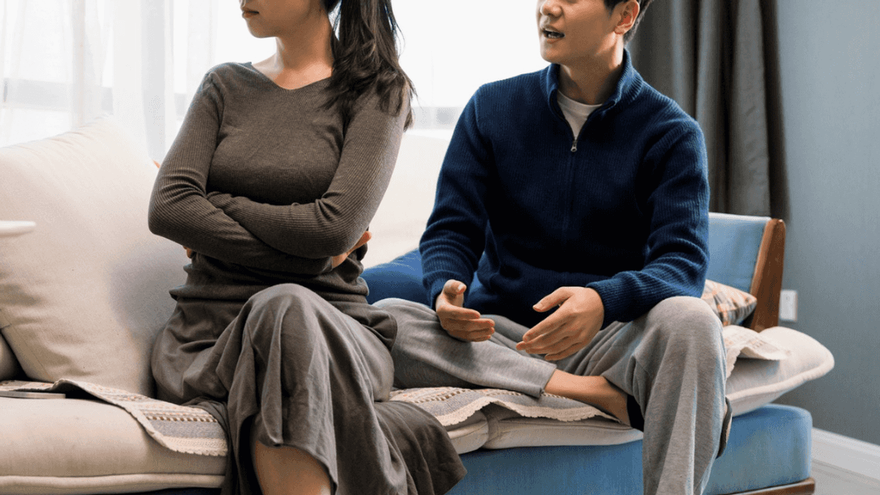 man and women seated on couch arguing