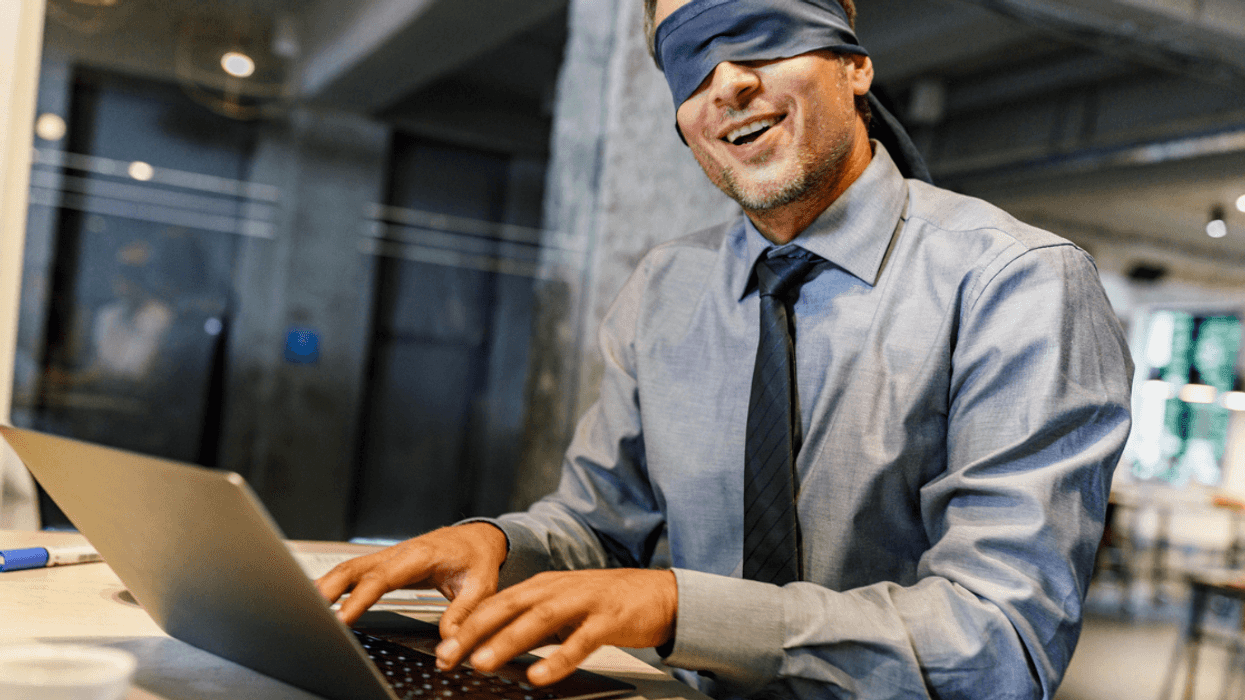Man attempting to type while blindfolded