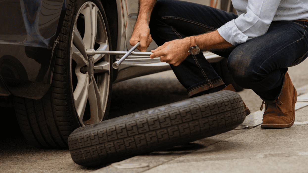 man changing flat tire