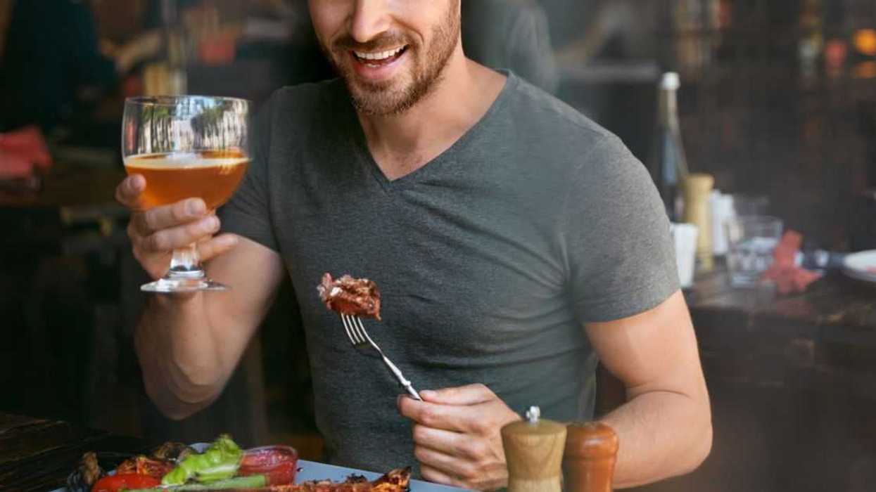 Man Drinking Craft Beer And Eating Steak In a Restaurant.