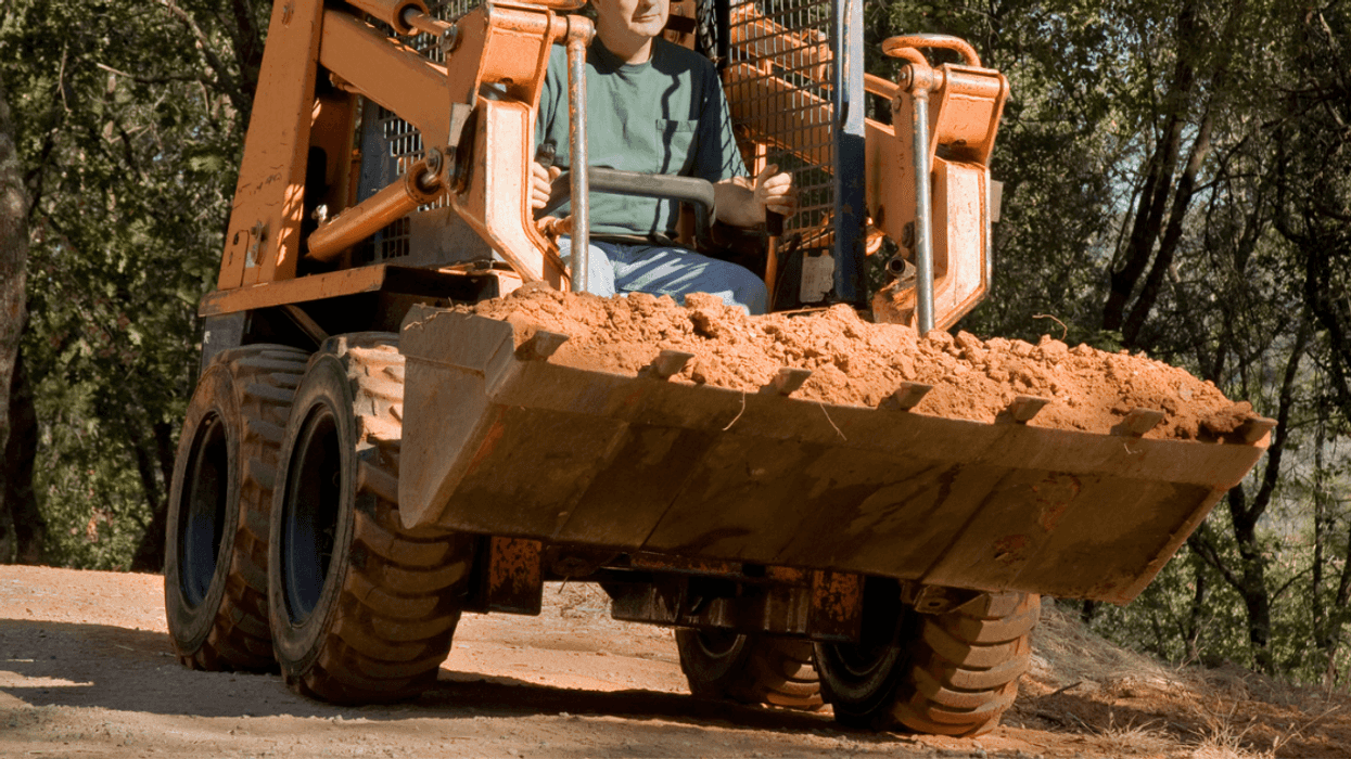 Man driving skid loader