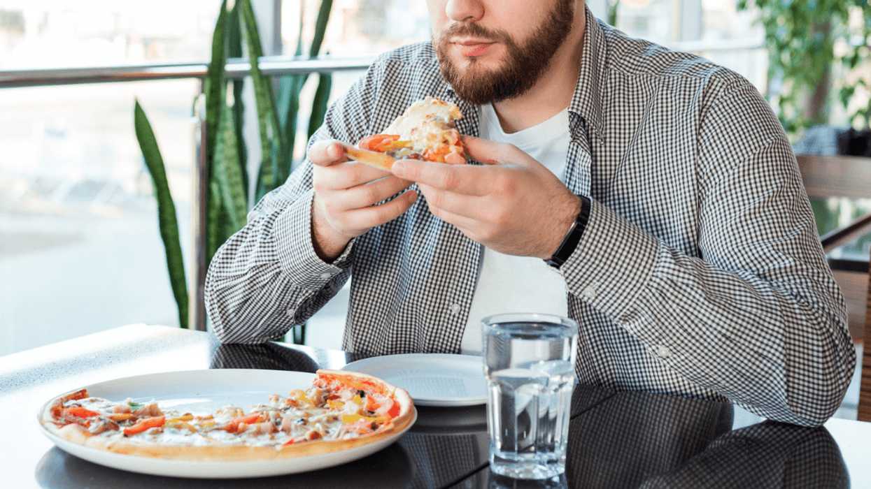 Man eating supreme pizza