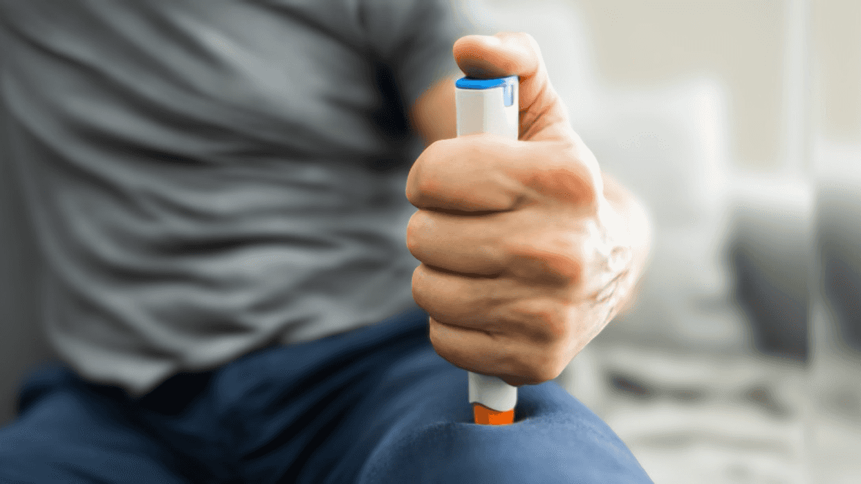 man giving himself shot with EpiPen